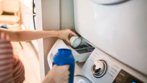 A top-load washing machine next to a dryer in a clean home laundry room