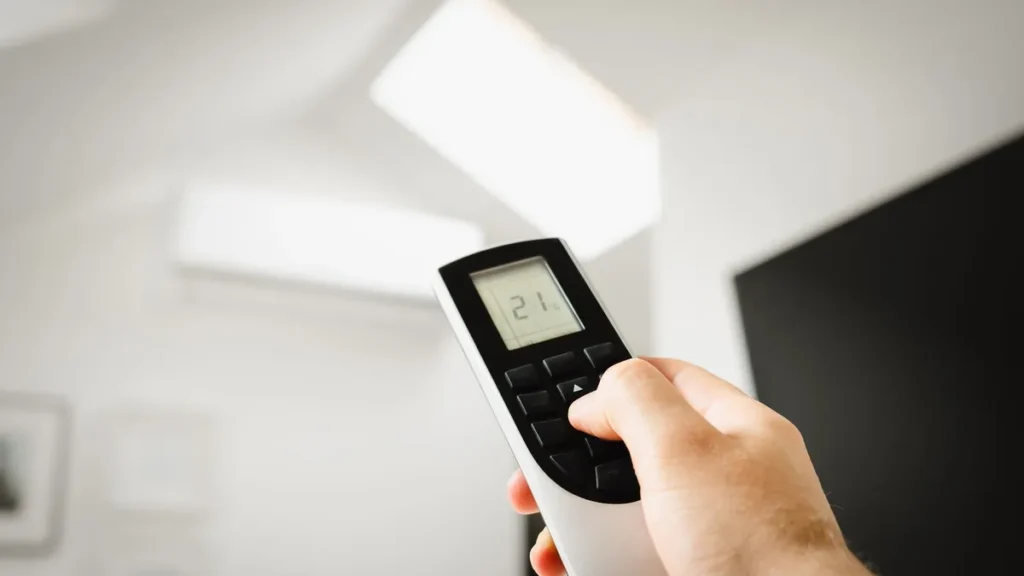 A digital wall thermostat set to cool in a home hallway