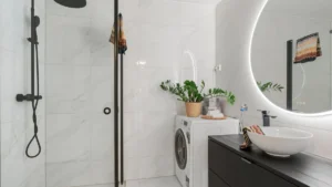 A modern front-load washing machine in a bright laundry room with folded towels nearby