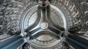 Looking into the stainless steel drum of a washing machine with laundry inside