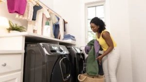 A white top-load washing machine with its lid open in a bright home laundry room